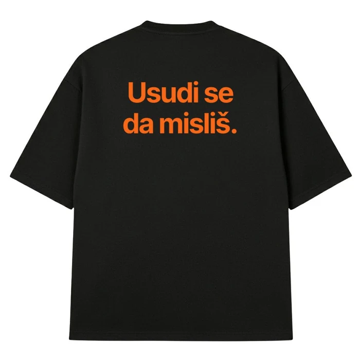 Crna oversize majica, na leđima narandžasta rečenica „Usudi se da misliš.“